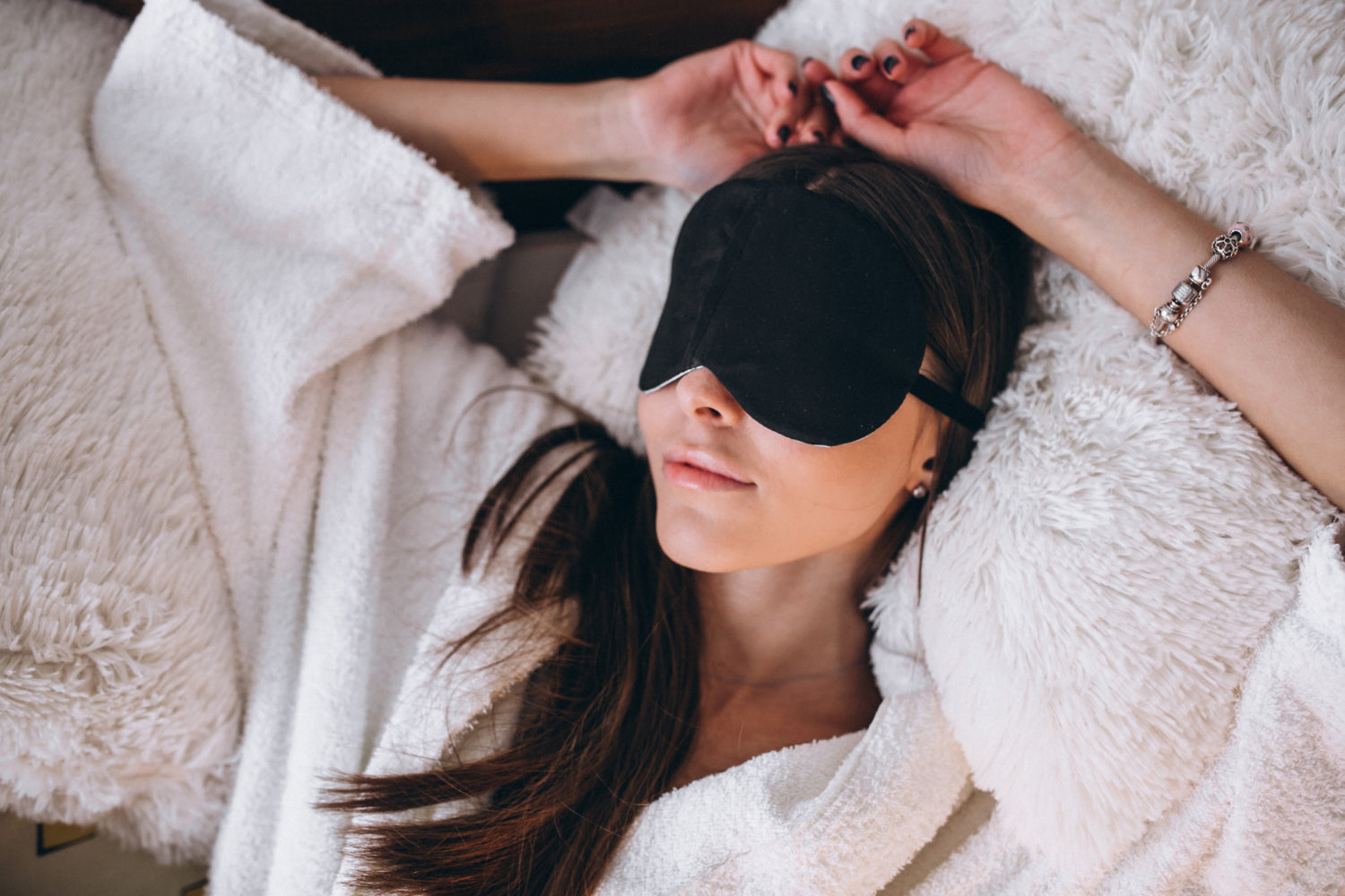 Vrouw die in bed ligt met een slaapmasker