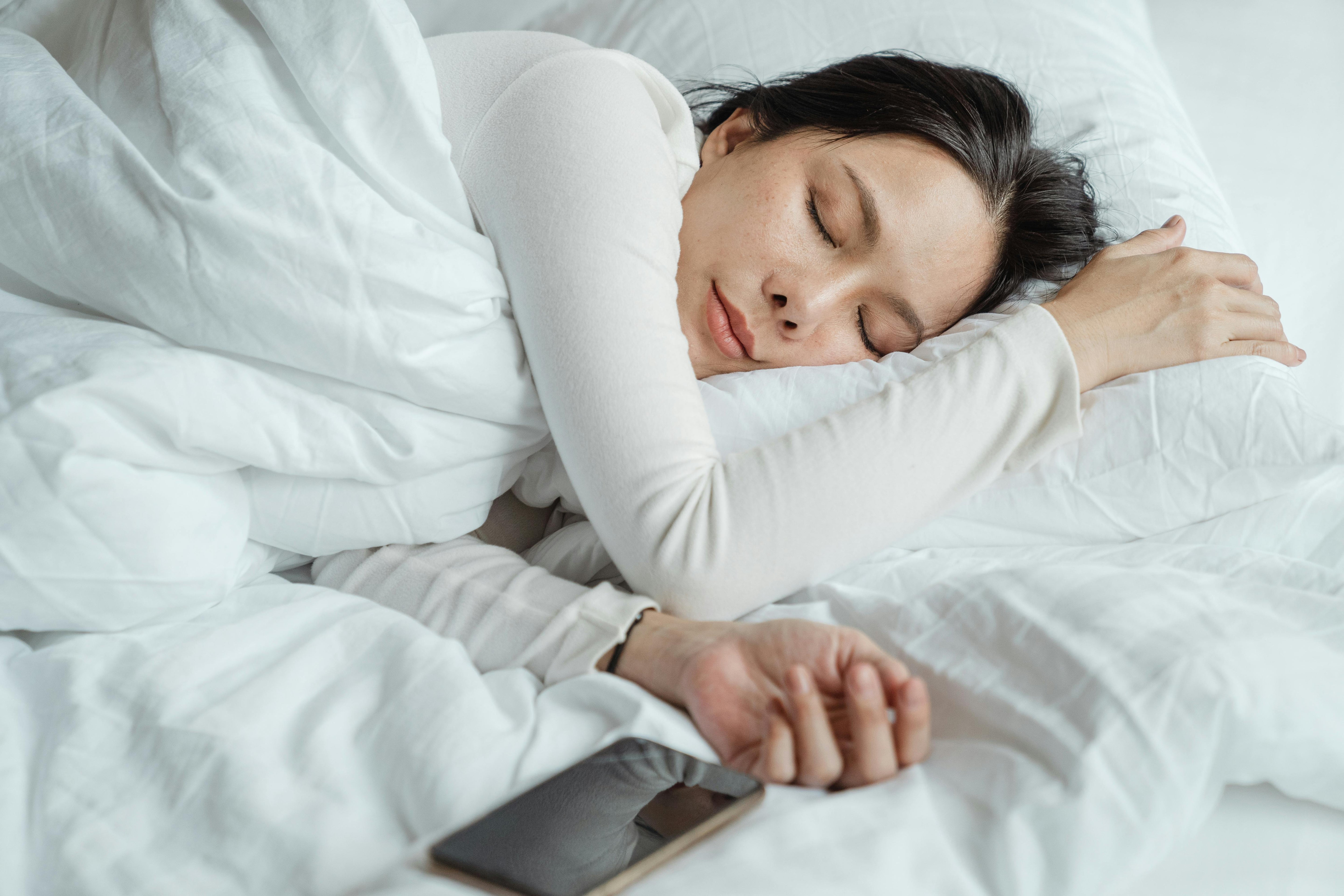 vrouw die in bed ligt te slapen